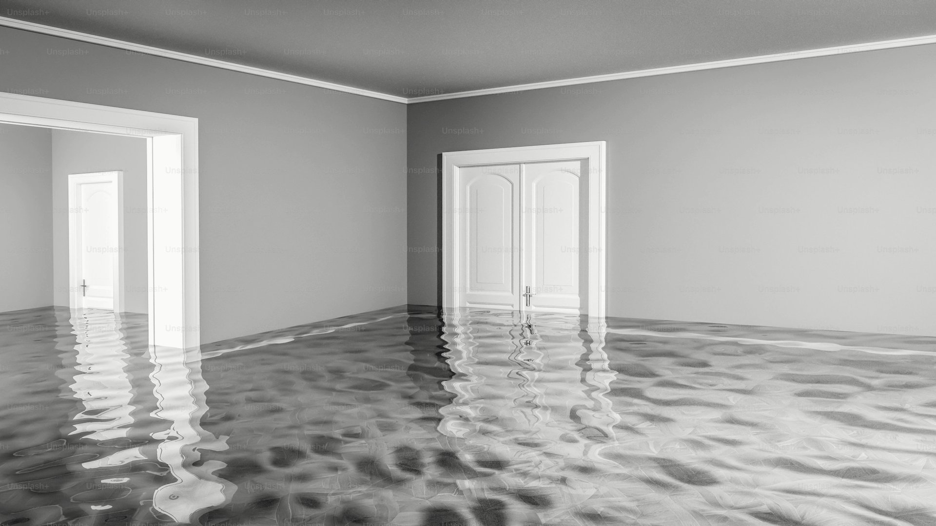 Water spreading across a hardwood floor from a burst supply line in a 1950s Westside multifamily unit.