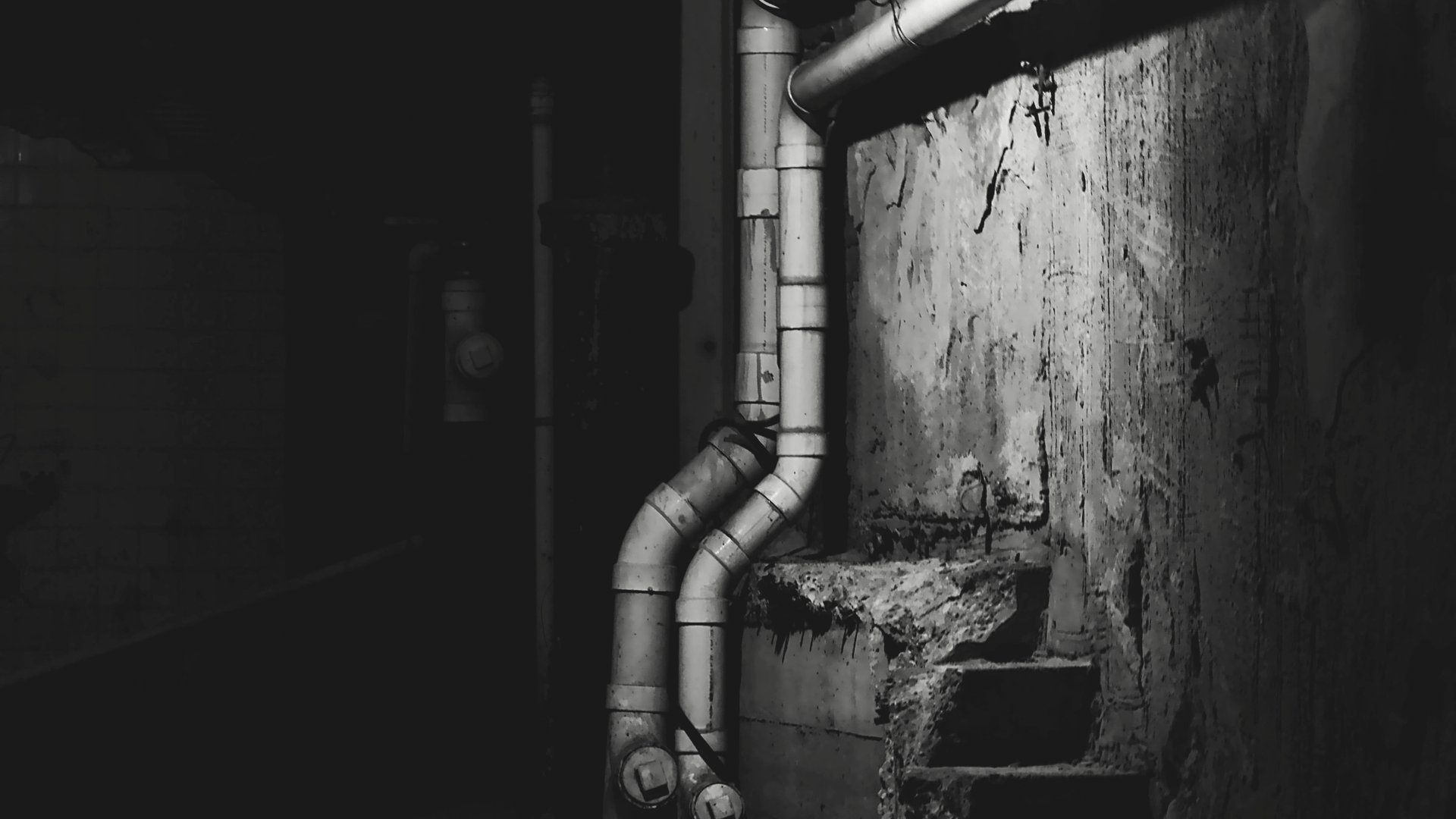 Excavated galvanized steel main water line exposed in a West LA residential yard — corrosion and scale visible along the pipe run.